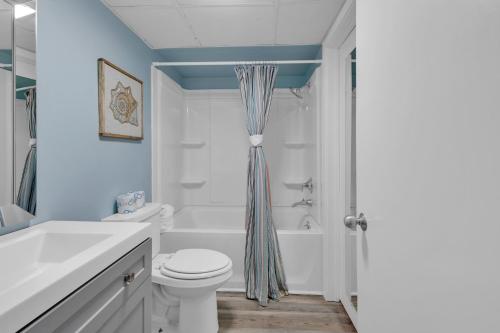 a white bathroom with a tub and a toilet at Ocean Front 2BR Elegant Condo in Atlantica Resort in Myrtle Beach