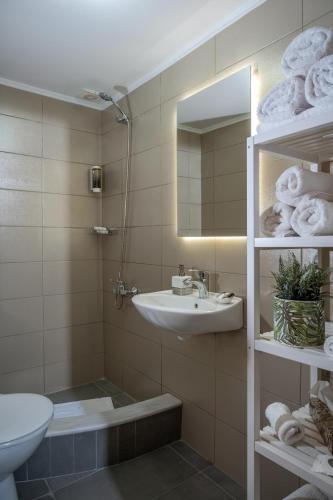 a bathroom with a sink and a toilet and a mirror at Rocca a Mare Maisonette I in Heraklio