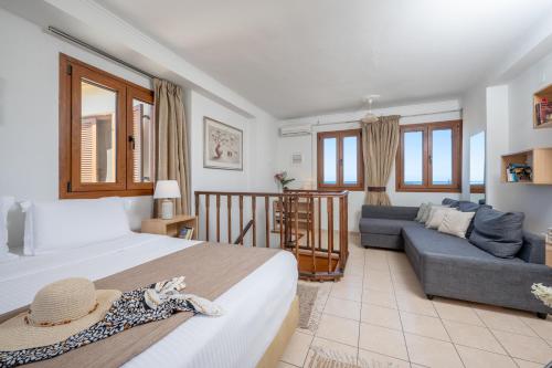 a bedroom with a large bed and a couch at Rocca a Mare Maisonette I in Heraklio Town