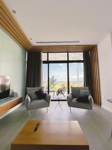 a living room with two chairs and a large window at Dreamview Suite Beachfront Getaway in Mağusa