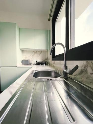 a kitchen with a stainless steel sink and a window at Dreamview Suite Beachfront Getaway in Mağusa
