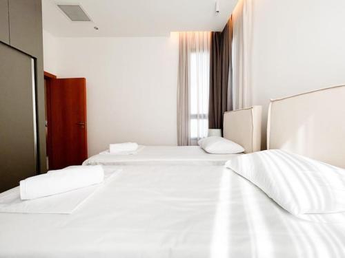two beds in a room with white sheets and pillows at Dreamview Suite Beachfront Getaway in Mağusa
