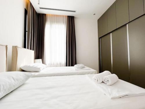 two beds in a hotel room with white sheets and towels at Dreamview Suite Beachfront Getaway in Mağusa