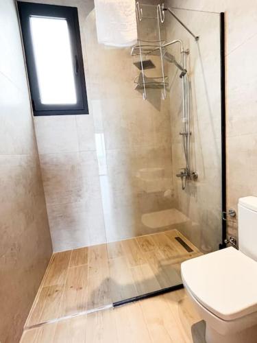a bathroom with a shower and a toilet and a window at Dreamview Suite Beachfront Getaway in Mağusa