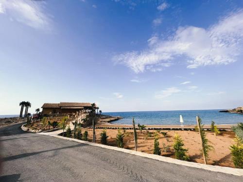 an empty road next to a beach with the ocean at Dreamview Suite Beachfront Getaway in Mağusa