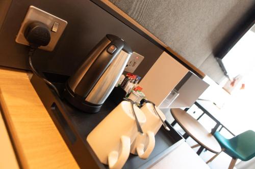 a room with a coffee maker and chairs at Holiday Inn Blackpool by IHG in Blackpool