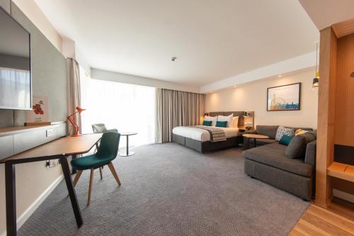 a hotel room with a bed and a living room at Holiday Inn Blackpool by IHG in Blackpool