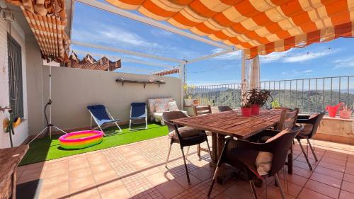 塞內斯德拉維加的住宿－CASA LOS ABETOS cerca de la Alhambra y Sierra Nevada，阳台的天井配有木桌和椅子