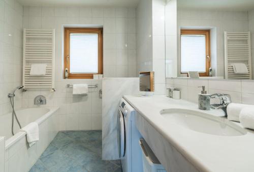a white bathroom with a tub and a sink and a bath tubermott at Apartment Bella Vista in Bad Kleinkirchheim