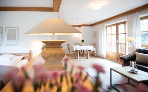 uma sala de estar com uma mesa e um candeeiro em Haus Lesch - Stilvolle Appartements mit tollem Bergblick in Kreuth am Tegernsee em Kreuth