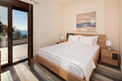 ein Schlafzimmer mit großem Bett und Balkon in der Unterkunft Corfu Travel Stories Villa, Private Pool - Stunning Sea Views - Accessible - 4 Bedrooms in Áno Pavliána
