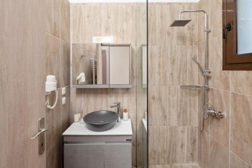 ein Badezimmer mit Waschbecken und Glasdusche in der Unterkunft Corfu Travel Stories Villa, Private Pool - Stunning Sea Views - Accessible - 4 Bedrooms in Áno Pavliána