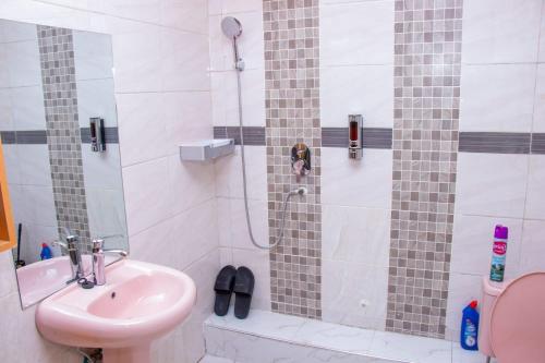 uma casa de banho com um chuveiro, um lavatório e um WC. em Deka B&B Ksh1500 em Nairobi