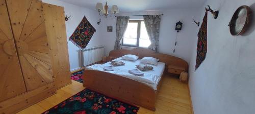 Un dormitorio con una cama y una puerta de madera. en Feel Free House, en Stulpicani