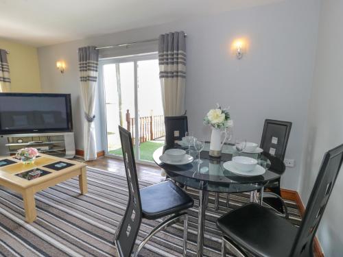 a living room with a table and chairs and a television at Sea Breeze in Caernarfon