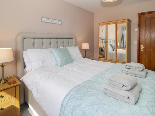 a bedroom with a bed with towels on it at Sea Breeze in Caernarfon
