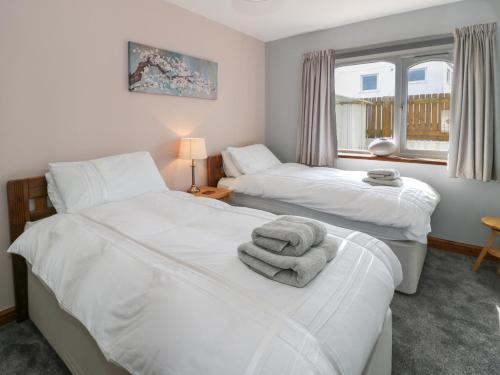 a bedroom with two beds with towels on them at Sea Breeze in Caernarfon