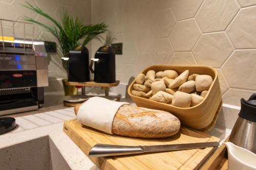 a cutting board with a loaf of bread and a knife at Holiday Inn Blackpool by IHG in Blackpool