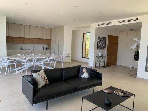 un salon avec un canapé noir et une table dans l'établissement VILLA IMPERIALE vue mer piscine, à Pietrosella