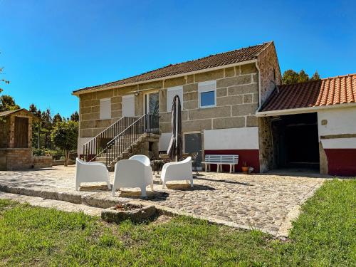 a group of white chairs sitting in front of a house at Casa S.Cláudio - rural home near Viana do Castelo in Nogueira