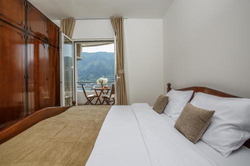 a bedroom with a bed and a balcony with a table at Soul of the Kotor Bay in Dobrota
