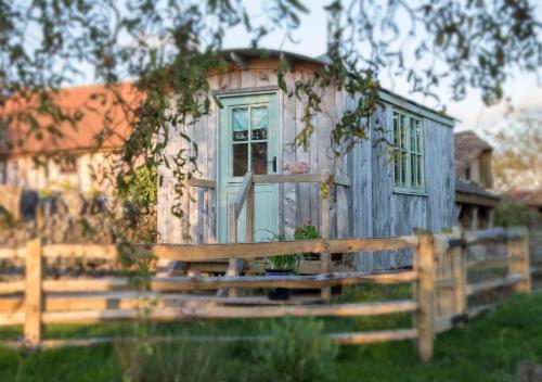 a blue tiny house behind a wooden fence at Old Shep's Shepherds Hut 