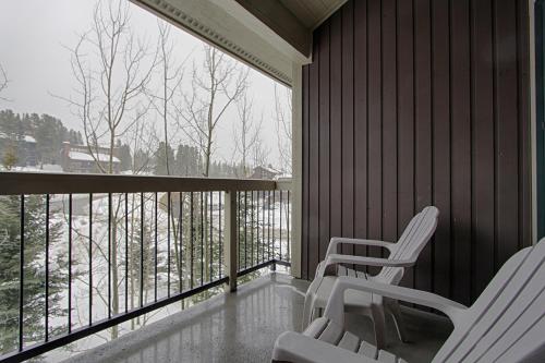 two white chairs on a balcony with a view of snow at Riverbend Lodge 217 by Great Western Lodging in Breckenridge