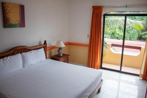 1 dormitorio con cama y ventana grande en Vista Caribe Playa en Playa del Carmen