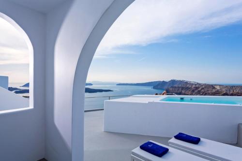 um quarto branco com vista para o oceano em Alti Santorini Suites em Megalochori