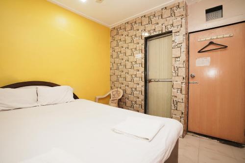 Harihara Residency في مومباي: غرفة نوم بسرير ابيض وباب
