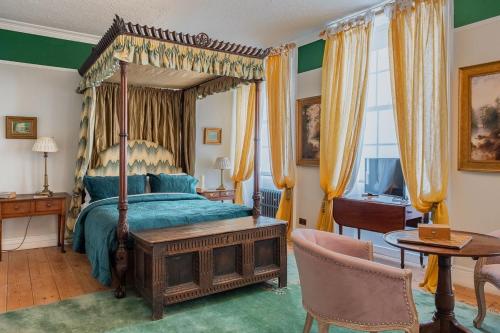 una camera con letto a baldacchino e tavolo e sedie di Luxury Georgian Townhouse in heart of Norwich Sleeps 4 a Norwich