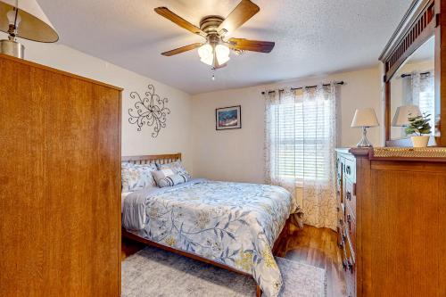 オークハーバーにあるWhidbey Way Beach Houseのベッドと天井扇風機のある寝室