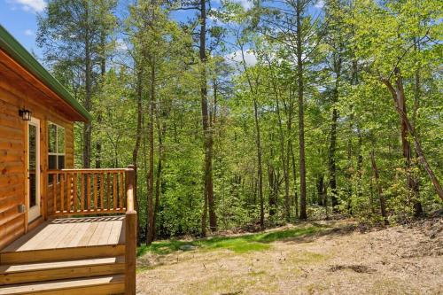 a wooden porch on a cabin in the woods at Baby Bear Den in Gatlinburg