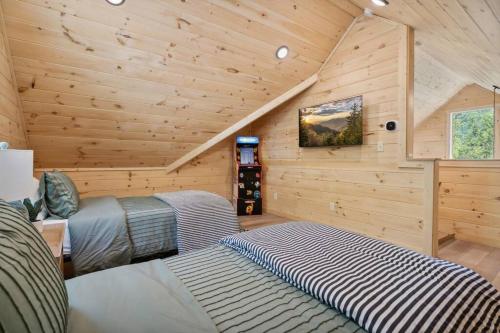 a bedroom with two beds in a log cabin at Baby Bear Den in Gatlinburg