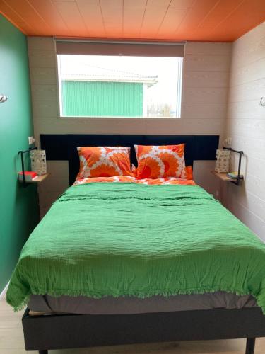 - une chambre avec un lit au plafond orange dans l'établissement The Cat’s Cradle, à Grundarfjörður