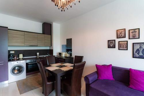 a kitchen with a table and a purple couch at Rezident Eforie Nord in Eforie Nord