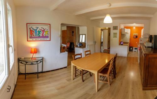 a dining room and living room with a table and chairs at Gite rue Tranquille in Padern