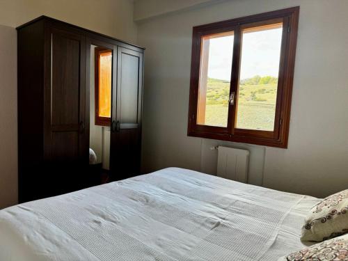 1 dormitorio con cama blanca y ventana en Host Roccaraso en Roccaraso