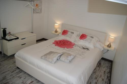 a bedroom with a white bed with red roses on the pillows at B&B Villa Castelnau Montpellier in Castelnau-le-Lez