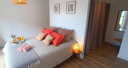 une chambre avec un lit avec des oreillers rouges dans l'établissement Maison neuve proche plage avec parking gratuit et privé à 5 min du musée de la Batterie de Merville, à Gonneville-en-Auge