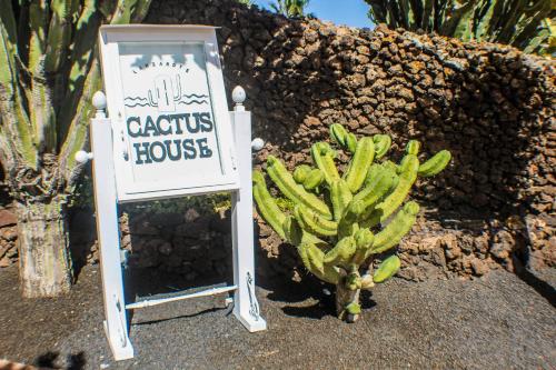 La AsomadaにあるCasa Cactus Piscina Climatizadaの植物の隣のサボテン家の看板