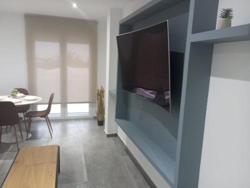 a living room with a flat screen tv on a wall at Gaviotas Beach Golf in Almerimar