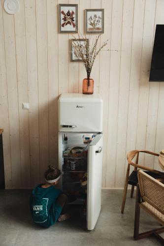 a man is laying on the floor next to a refrigerator at Garczovka - domki, jacuzzi, sauna in Garcz