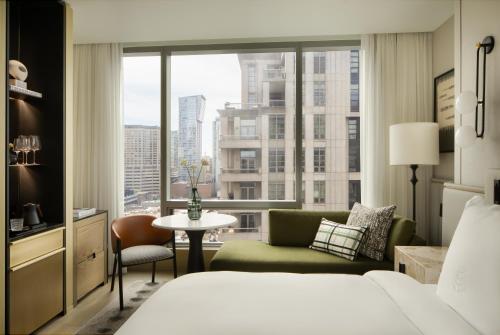 a hotel room with a bed and a couch and a window at Four Seasons Hotel Toronto at Yorkville in Toronto