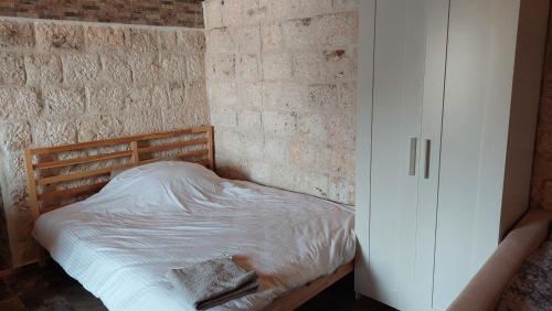 1 cama en un dormitorio con pared de ladrillo en Kekova Hassan's Pansiyon, en Demre