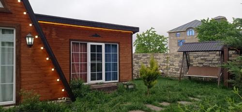 una pequeña casa con luces en el lateral. en A frame for families en Quba
