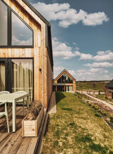a wooden house with a picnic table on a deck at Garczovka - domki, jacuzzi, sauna in Garcz