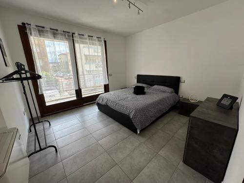 una camera da letto con un letto e due finestre di Gris I Blanca apartment ad Alghero