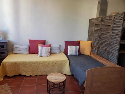 a room with a bed and a couch with pillows at Mini Loft in Cassis