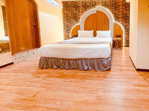 a bedroom with a large bed in a room at Hotel Nova Bopal in Bodakdev